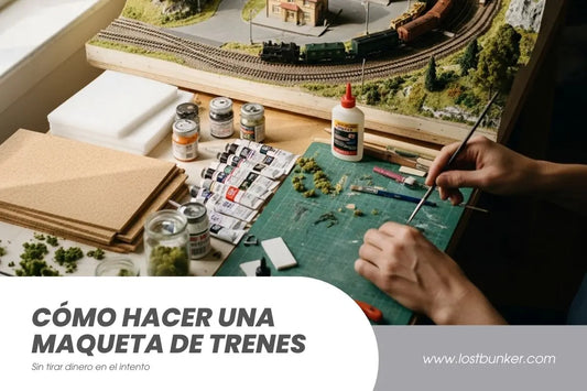Manos trabajando en maqueta de trenes sobre tapete de corte con herramientas de modelismo, pinturas acrílicas y pegamento, mostrando cómo hacer una maqueta ferroviaria paso a paso